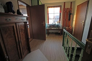 A hallway with wooden doors, a radiator, and a window with curtains. - Vacation apartment Vieth in Sassnitz on Rügen with seating area in the garden (Sassnitz auf Rügen)