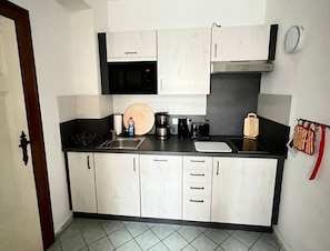Eine kleine Küche mit Mikrowelle, Kaffeemaschine und Toaster.