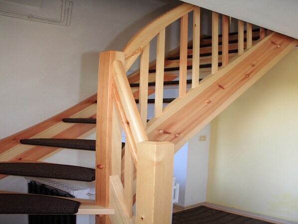 Eine Holztreppe mit Handlauf und Zwischenpodest.