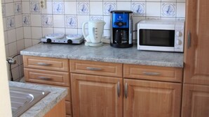 Een keuken met een koffiezetapparaat, een broodrooster en een magnetron op het aanrecht.