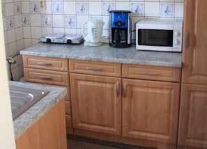 Eine Küche mit einer Kaffeemaschine, einem Toaster und einer Mikrowelle auf der Arbeitsplatte.