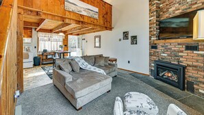 Ein gemütliches Wohnzimmer mit Kamin, einer Couch und einem Essbereich.