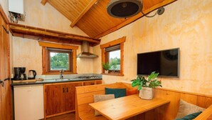 Een kleine keuken met houten kastjes, een inbouwfornuis en een spoelbak.