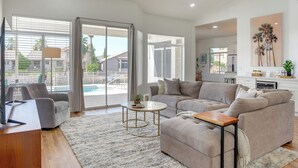 A modern living room with a sectional sofa, a coffee table, and a TV on a wooden stand. - Pool + Lakefront: Upscale Glendale Getaway (Glendale)