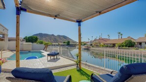 A covered patio with a pool, lounge chairs, and a view of a mountain. - Pool + Lakefront: Upscale Glendale Getaway (Glendale)