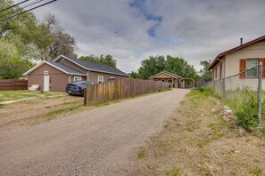 En boligvej med huse på hver side, et træhegn og en grussti.