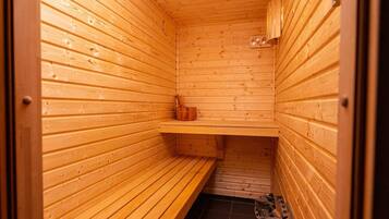 A sauna with wooden walls and benches, a shelf, and a tiled floor.