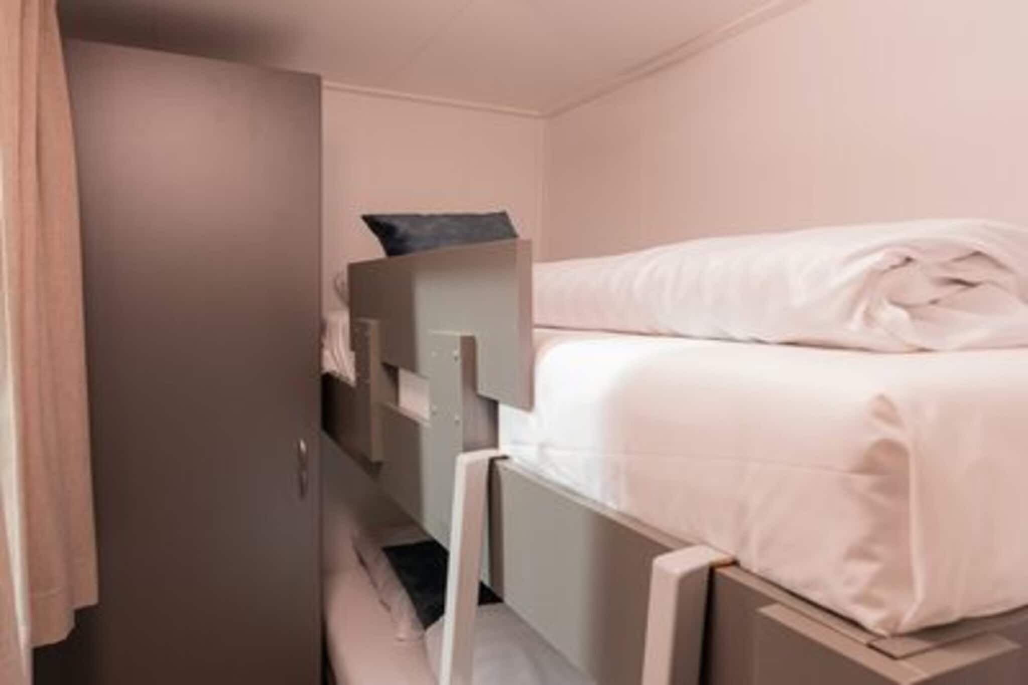 Una habitación pequeña con cama, armario y una mesita.