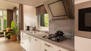 A modern kitchen with a gas stove, a built-in oven, and a large window.