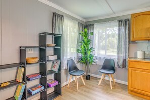 Une pièce comprenant une bibliothèque, deux chaises, une plante en pot et un meuble en bois.