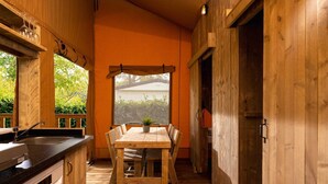 Interior de madera con una mesa de comedor, sillas, una ventana con vistas y un lavamanos.