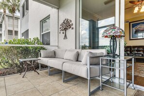 Ein modernes Wohnzimmer mit einer Couch, einem Glastisch und einem dekorativen Metallbaum.