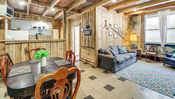 A rustic interior with a wooden dining table, chairs, a sofa, and a patterned rug. - 'Old School ATV Retreat' On Warrior Trail, 8BR (Gary)