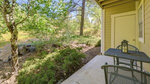 A covered patio with a table and chairs, surrounded by trees and a natural landscape. - Shop, Dine, Hike, Explore Dtwn! Flagstaff Getaway (Flagstaff)