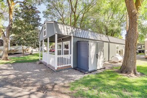Eine kleine, eingeschossige Hütte mit Veranda und Garage.