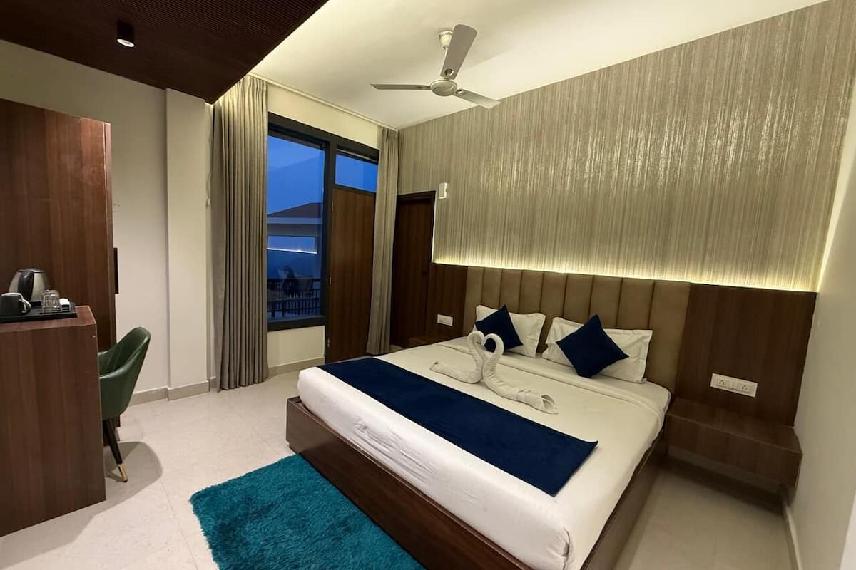 Una habitación de hotel moderna con una cama grande, un escritorio y vistas a la ciudad.