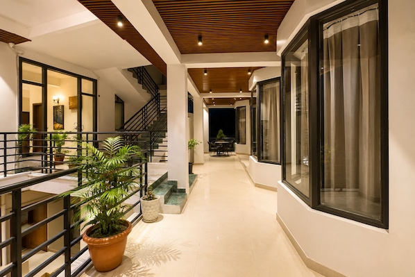 A modern interior with a staircase, potted plants, and a dining area. - Hotel Heaven & Hills Kasauli (Kasauli)