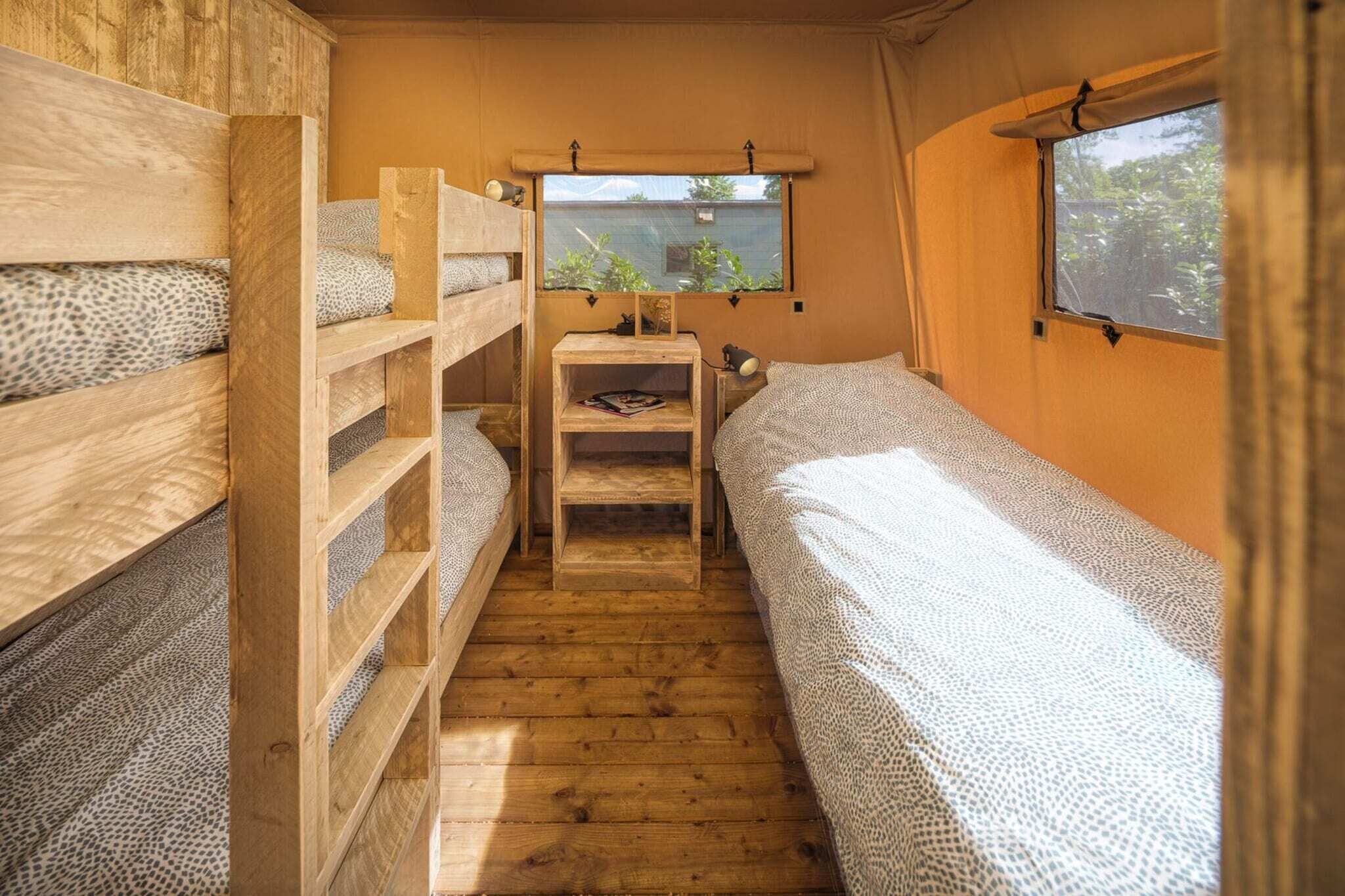 Una cabana petita i senzilla, d'una sola estança, amb dos llits superposats, un taulell de fusta petit i una finestra que dona a vegetació.
