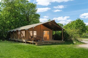 Een houten hut met een veranda, een deur en een raam.
