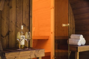 A wooden interior with a table holding a bottle and two glasses. - Bungalow with Nursery and Playground (Zuna)