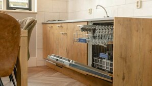A kitchen with wooden cabinets, a dishwasher, and a window.