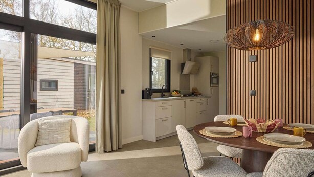 A modern kitchen with a dining area, large windows, and a view of the outside. - Luxury Family Lodge with Hot Tub (Zuna)