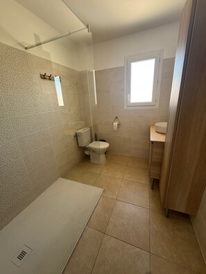 A bathroom with a shower, toilet, and sink, featuring tiled walls and floor. - 3-bedroom villa with garage, covered terrace and air-conditioned pétanque court (Raphele les Arles)