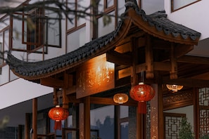 A traditional building with wooden architecture, including a curved roof and decorative lanterns. - Tangwan Mountain Homestay - Yangjiajie  (Zhangjiajie)