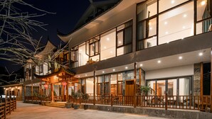 A multi-story building with traditional architecture, large windows, and a balcony area. - Shiyi Tangwan Yangjiajie Lodge (Zhangjiajie)