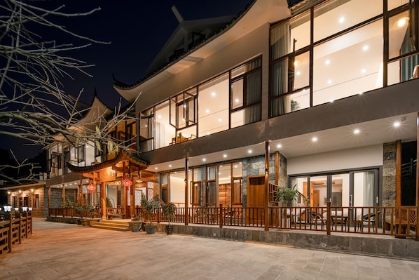 A multi-story building with traditional architecture, large windows, and a balcony area. - Tangwan Mountain Homestay - Yangjiajie  (Zhangjiajie)