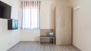 A room with a wooden wardrobe, a bench, and a window with curtains. - Hotiday Villa San Domenico (Rosignano Marittimo)