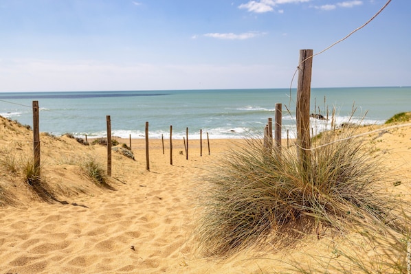 A sandy beach with a wooden fence and grass. - HARPON - Between the Old Port & the Historic Heart (Saint-Gilles-Croix-de-Vie)