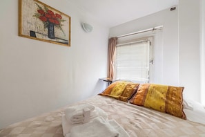 A hotel room with a bed, a painting, a window with curtains, and a bedside table. - A/C apartment with balcony- 2BDR/4P - Cannes/Beach (Cannes)