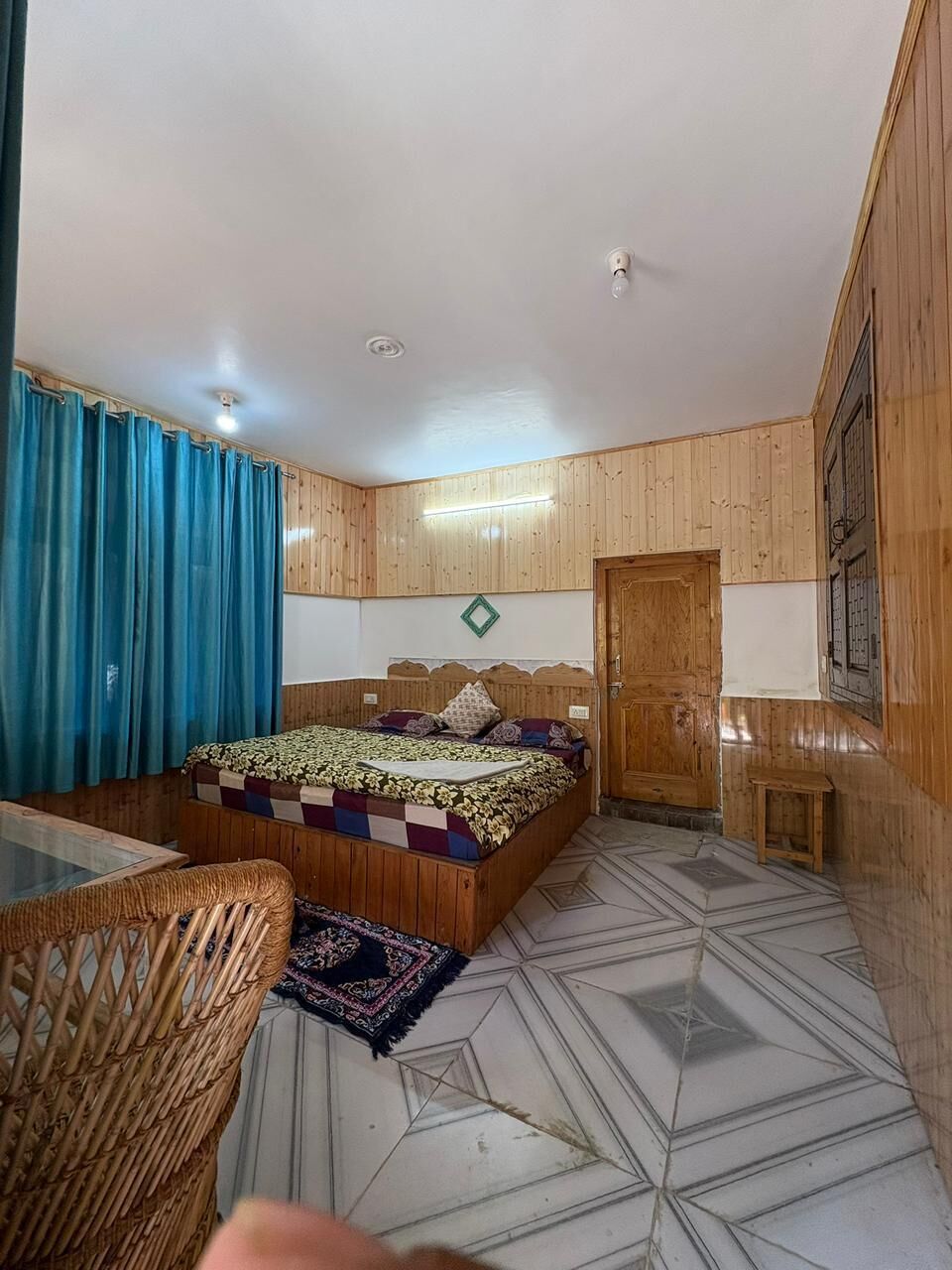 Une chambre à coucher avec un lit, une armoire en bois, une petite table et une chaise.