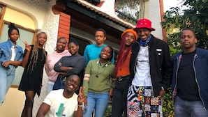 A group of people posing in front of a building with a tiled roof and a brick wall. - Jungle Nairobi Backpackers Hostel (Nairobi)
