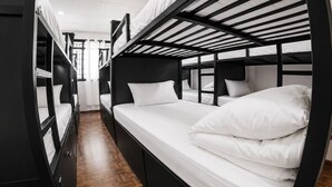 A bunk bed room with a wooden floor, black metal frame, and white bedding. - Jungle Nairobi Backpackers Hostel (Nairobi)