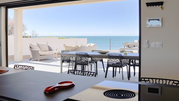 An open balcony with a table and chairs, a sofa, and a view of the sea. - Magnificent sea view from this apartment (Agde)