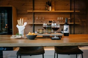 Eine Holztresore mit einer Weinflasche, Gläsern und Snacks.