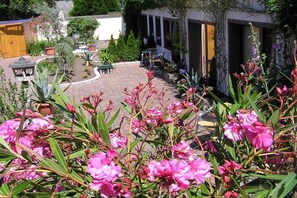A courtyard with potted plants, a gazebo, and outdoor seating. - Small Island Double Room - Plus (Ostseebad Heringsdorf)