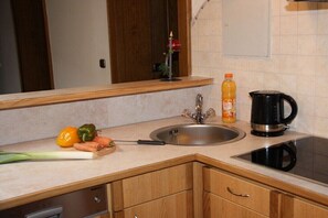 A kitchen with a sink, a coffee maker, and some vegetables on the counter. - Holiday apartment with 2 bedrooms (Krimml)