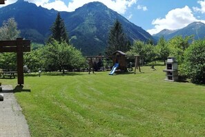 A park with a playground, picnic tables, and a mountain backdrop. - Holiday apartment with 2 bedrooms (Krimml)