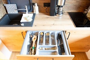 A kitchen with a sink, a coffee maker, and a drawer with utensils. - Apartment in Mittelberg with swimming pool (Mittelberg)