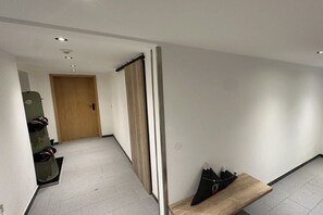 A hallway with a wooden door, a bench, and a shoe rack. - Apartment in Mittelberg with swimming pool (Mittelberg)