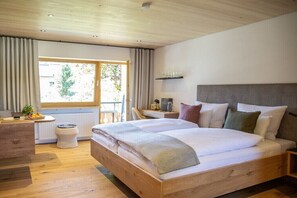 A bedroom with a wooden bed, a desk, a chair, a radiator, and a window with curtains. - Apartment in Mittelberg with swimming pool (Mittelberg)