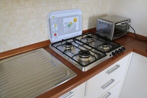 Eine Küche mit Gasherd, Toaster und Mikrowelle.