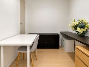 A small, modern kitchen with a white countertop, a black cabinet, and a wooden cabinet.