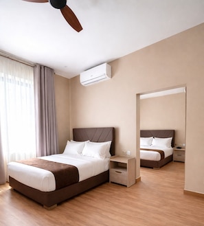 Habitación de hotel con cama, mesita de noche y aire acondicionado.