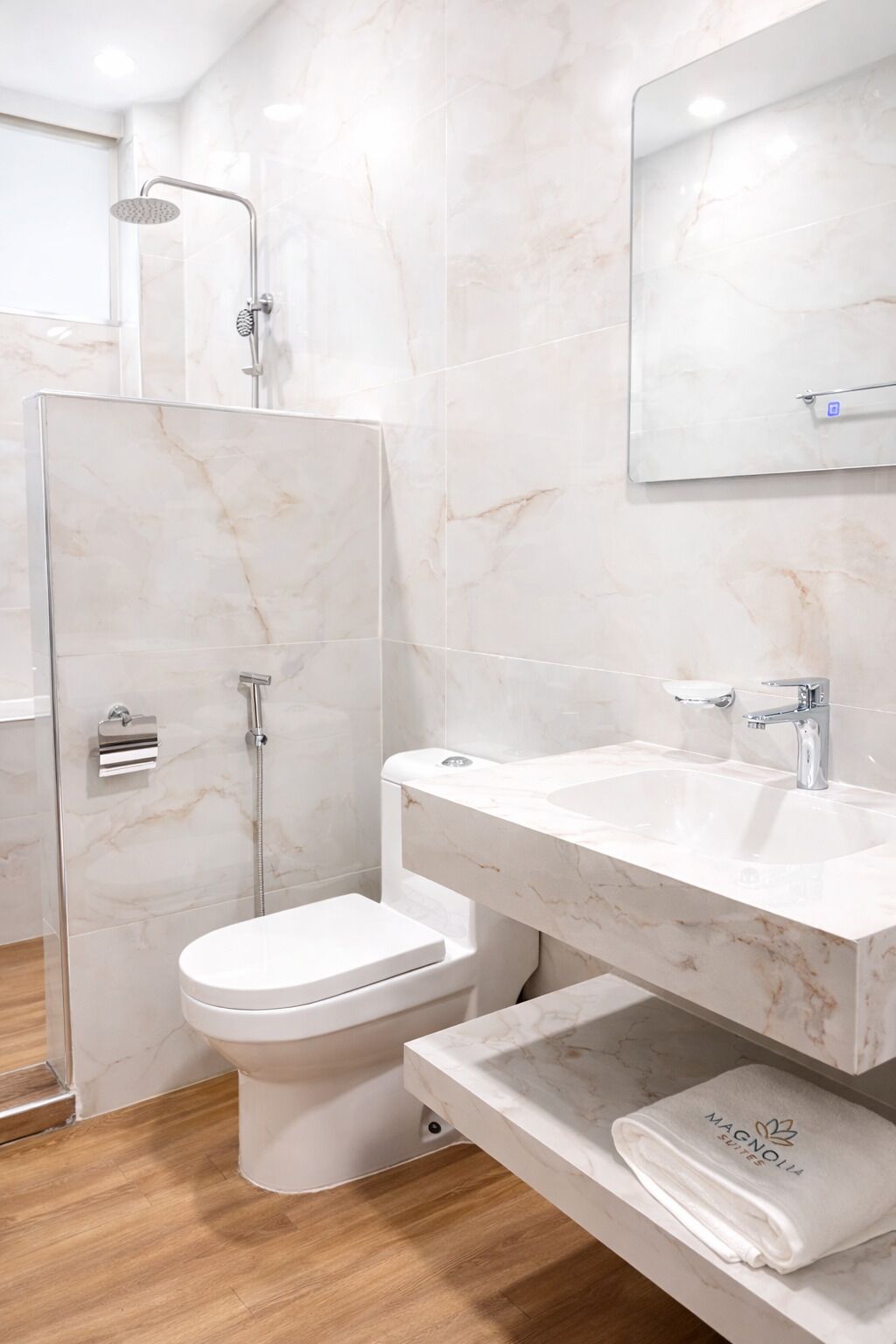 A modern bathroom with a shower, toilet, sink, and a towel rack.