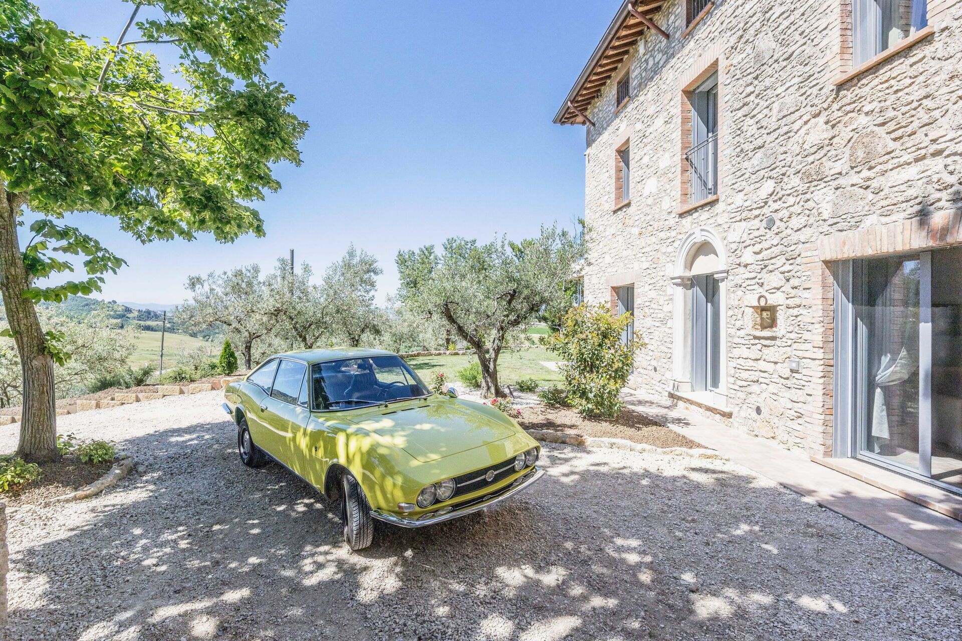 Un bâtiment en pierre avec une voiture garée devant.