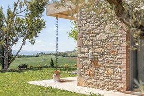 A stone building with a hanging planter and a view of a green landscape. - Villa in Canale with 5 bedrooms sleeps 14 (Canale)